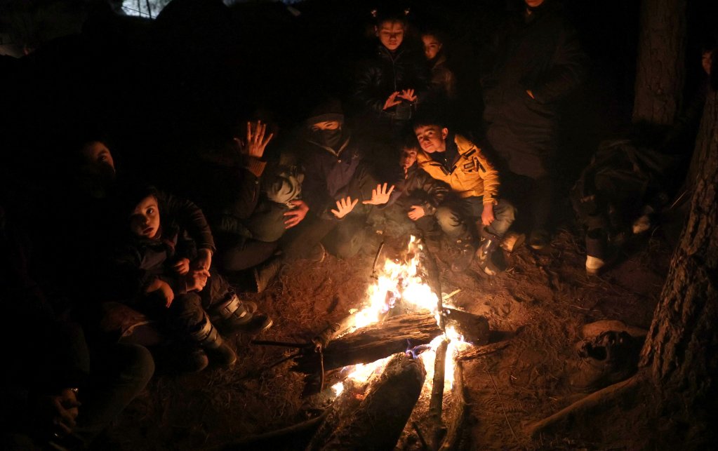 Des exilés tentent de se réchauffer près d'un feu, à la frontière entre la Pologne et la Biélorussie. Crédit : Reuters