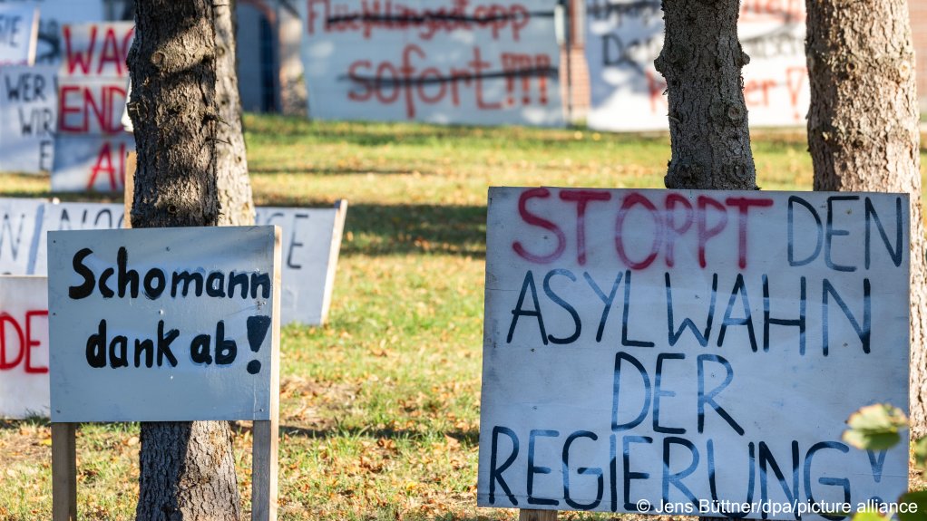 A protest sign with the crossed-out inscription "Stop the government's asylum mania" stands in the small northeastern German village of Upahl, where residents have protested against a controversial asylum seeker housing for months | Photo: Jens Büttner/picture-alliance