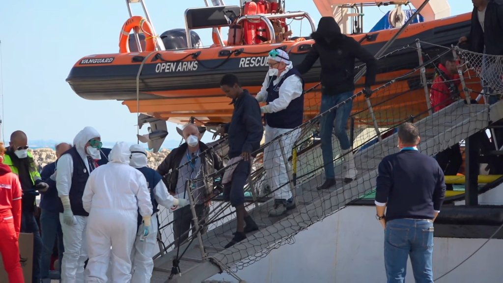 Some of the 363 migrants who disembarked in Italy on February 2 walk down the gangplank to health checks | Photo: Reuters