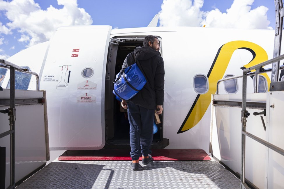 A migrant boards a flight to Pakistan at Benina Airport in Benghazi, Libya, as part of IOM’s Voluntary Humanitarian Return (VHR) program | Photo: Mouaiad Duffani /IOM