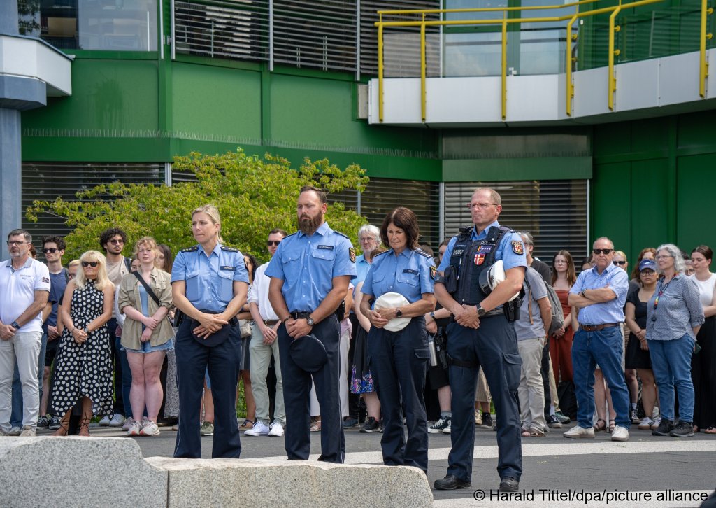 Police officers and other mourners express their condolences in the forum square of the University of Trier, following the fatal stabbing of a young student | Photo: Harald Tittel / dpa / picture alliance
