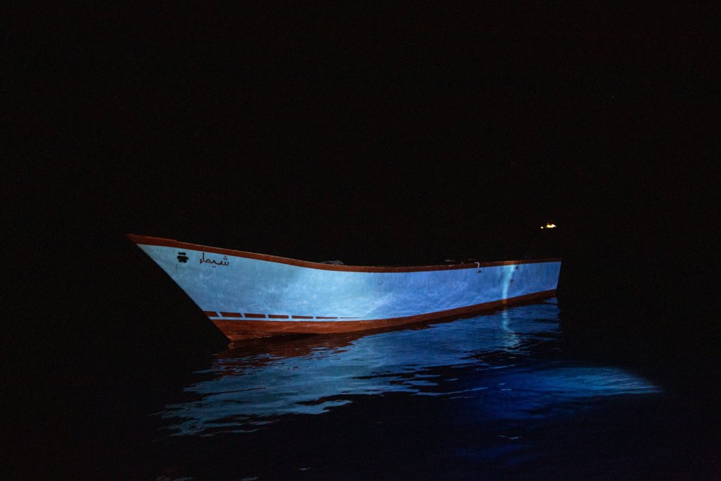 Wooden fishing boat in calm waters at night | Photo: SOS Humanity