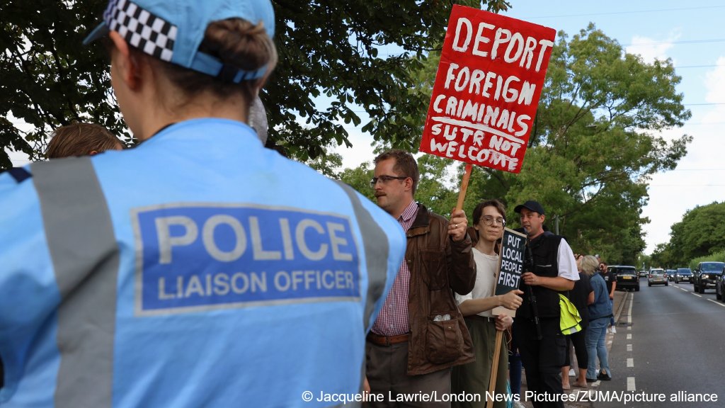 Protesters hold a placard, at The Bell hotel in Epping, Essex, England, where local residents are protesting against the housing of migrants, July 20, 205 | Photo: Jacqueline Lawrie/London News Pictures via ZUMA Press Wire