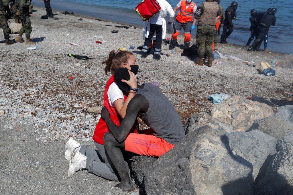 Un migrant subsaharien tombe dans les bras d'une bénévole de la Croix-Rouge, à Ceuta. Crédit : Reuters