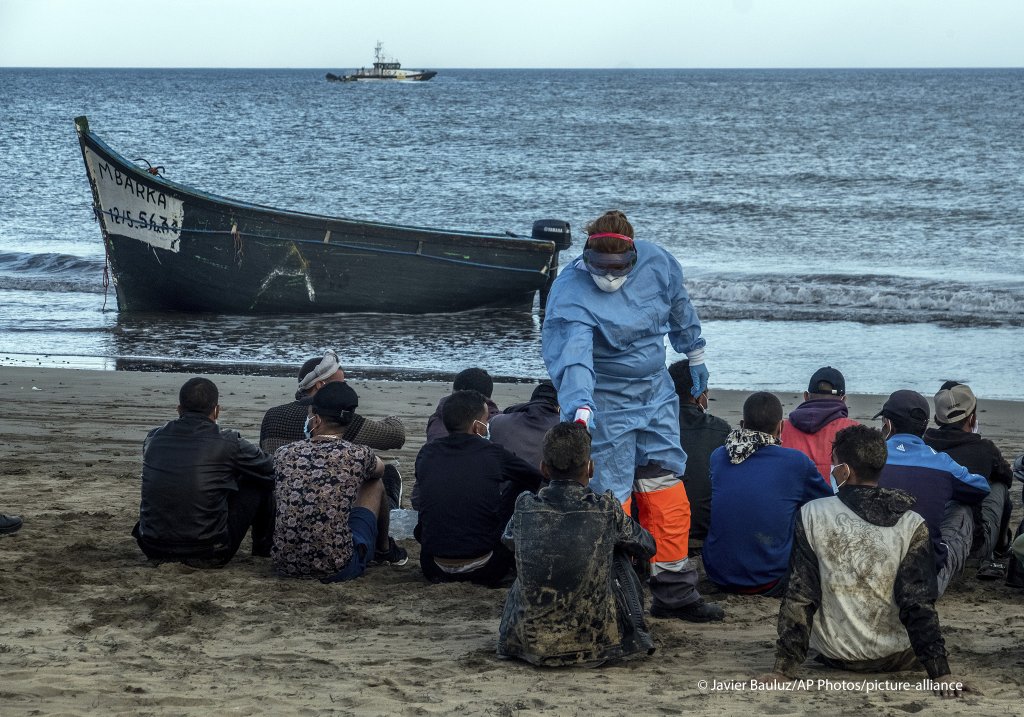 Migrants from Morocco have their temperature checked because of the coronavirus, after arriving at the coast of the Canary Island, crossing the Atlantic Ocean sailing on a wooden boat on October20, 2020 | Photo: picture alliance/AP Photo