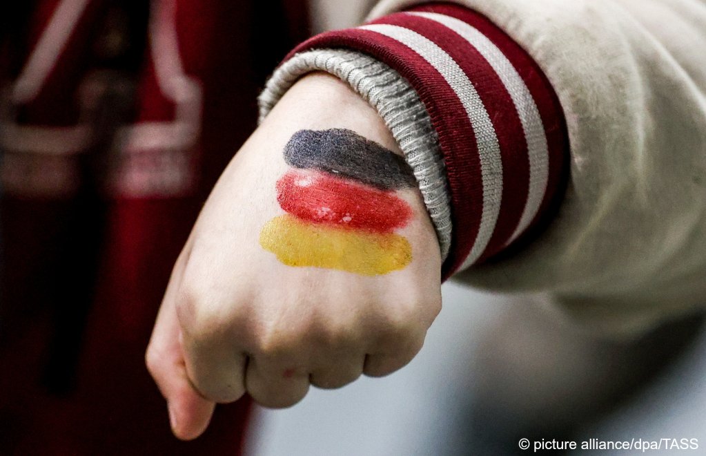 A refugee girl shows her hand painted in the German national colors at the Bruzgi Transport and Logistics Centre | Photo: Sergei Bobylev/TASS/dpa/picture alliance