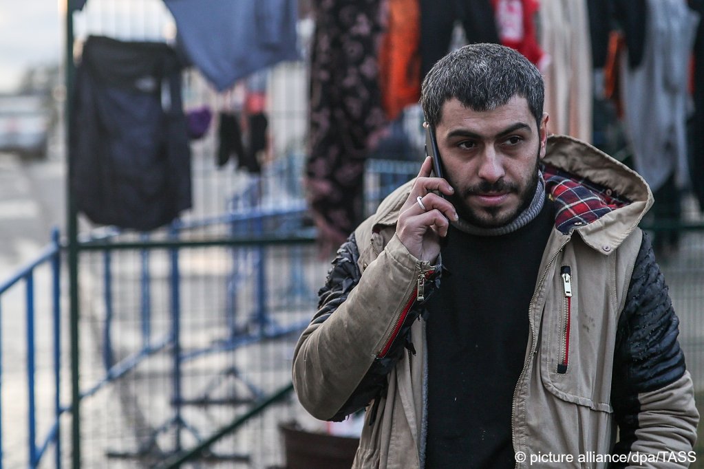  A migrant talks on the phone by the Bruzgi transport and logistics center on November 22, 2021 | Photo: Sergei Bobylev/TASS/dpa/picture-alliance