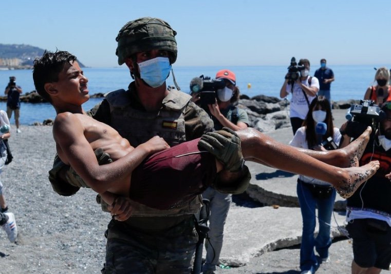 Un jeune garçon porté par un soldat espagnol dans l'enclave espagnole de Ceuta, en mai 2021. Crédit : Reuters