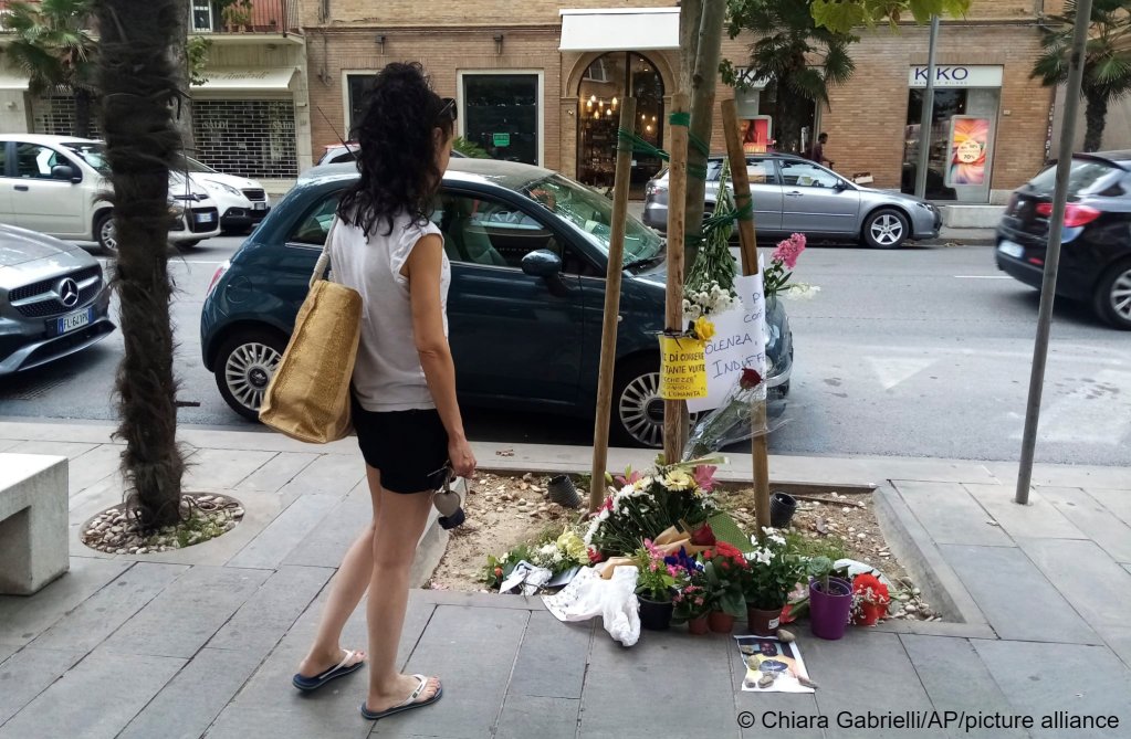 An Italian passer by looks at flowers laid to mark where Nigerian migrant Alika Ogorchukwu was killed | Photo: Chiara Gabrielli / picture alliance / AP