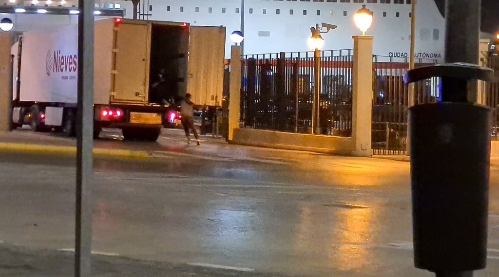 مهاجرون يحاولون الصعود إلى صندوق إحدى الشاحنات المتوجهة إلى رصيف الميناء، 20 أيار/مايو 2021. شريف بيبي/مهاجر نيوز