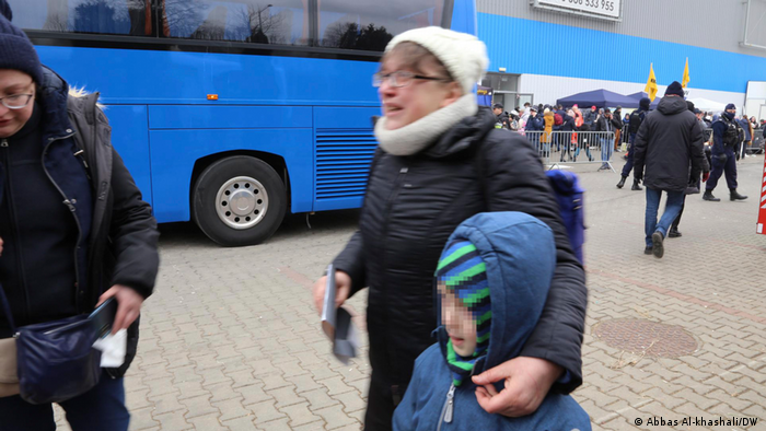 لاجئة أوكرانية مع حفيدها وابنتها يبحثون عن حافلة تنقلهم من الحدود إلى داخل بولندا