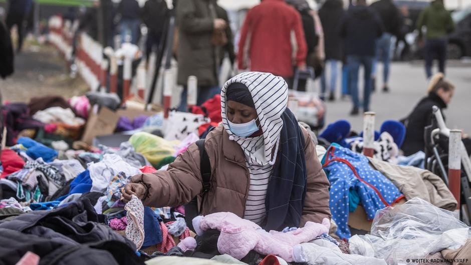 A woman tries to find some clothes for her after fleeing from Ukraine into Poland | Photo: Wojtek Radwanski/AFP