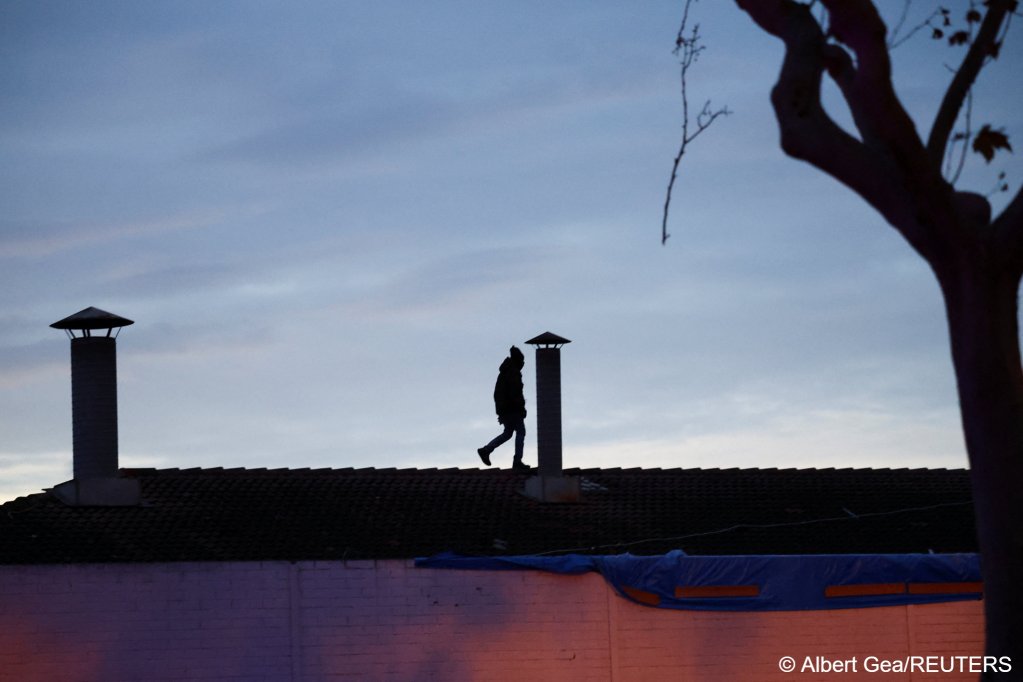A man walks on the roof of the abandoned school, target of a police eviction in the early hours of Wednesday morning | Photo: Albert Gea / Reuters