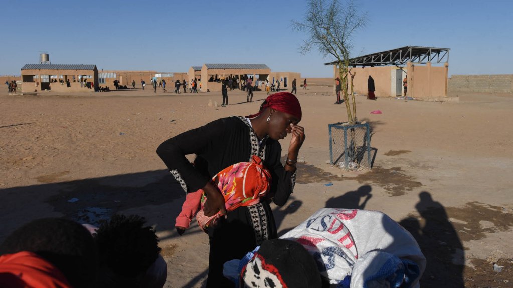 Une Malienne refoulée d'Algérie attend à un point d'eau à proximité du camp de transit d'Assamaka, dans le nord du Niger. Crédit: Mehdi Chebil