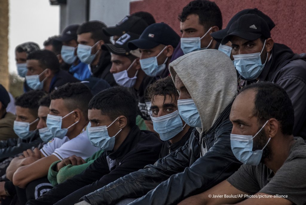 Migrants from Morocco sit after arriving at the coast of the Canary Island, crossing the Atlantic Ocean sailing on a wooden boat on October 20, 2020 | Photo: picture alliance/AP Photo