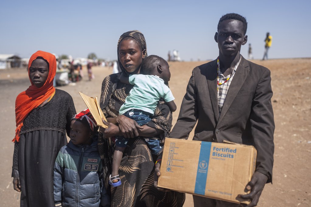 Families carry their belongings as they arrive in the South Sudanese town of Renk after fleeing fighting in Sudan | Photo: Hugh Rutherford/WFP