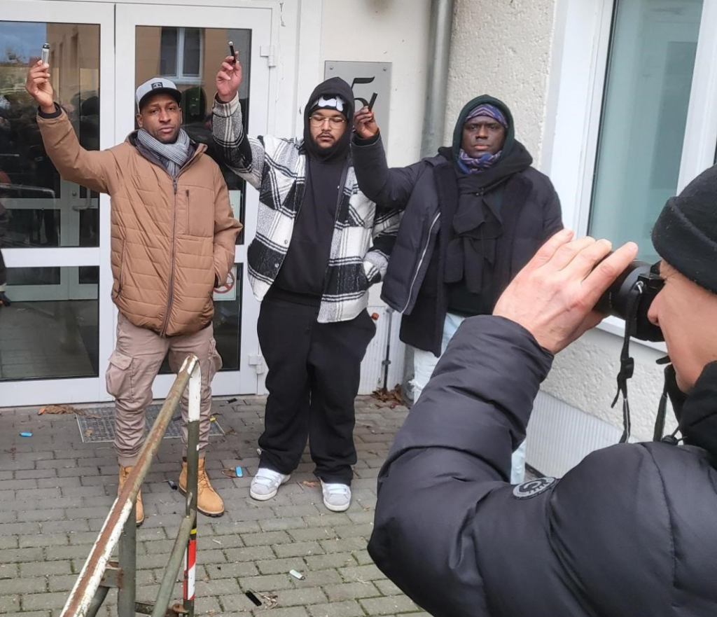 Oury Jalloh's brother Saliou Diallo, his son Felix and friend Mouctar Bah holding up cigarette lighters in front of Dessau's Office of the Public Prosecutor to protest inconsistencies, negligence and serious errors in how police and investigating authorities handled the case | Photo: Benjamin Bathke