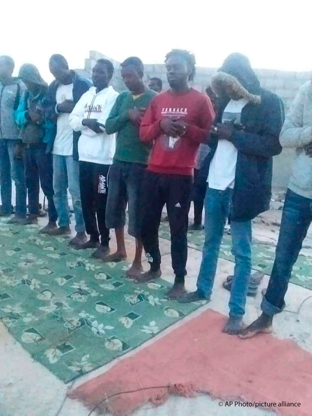 In this photo provided by the family of Mubarak Jaber, one of the victims of the April 22 shipwreck, Jaber and other migrants are seen praying before they prepare to board a smuggler’s boat in the town of al-Khums, Libya, April 20, 2021 | Photo: Family handout via AP/Picture-alliance