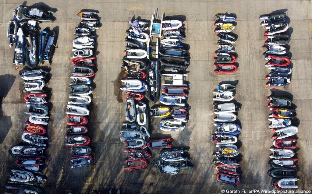 Rubber boats used by migrants to cross the English Channel are piled up near a port storage | picture alliance/dpa/PA Wire | Gareth Fuller