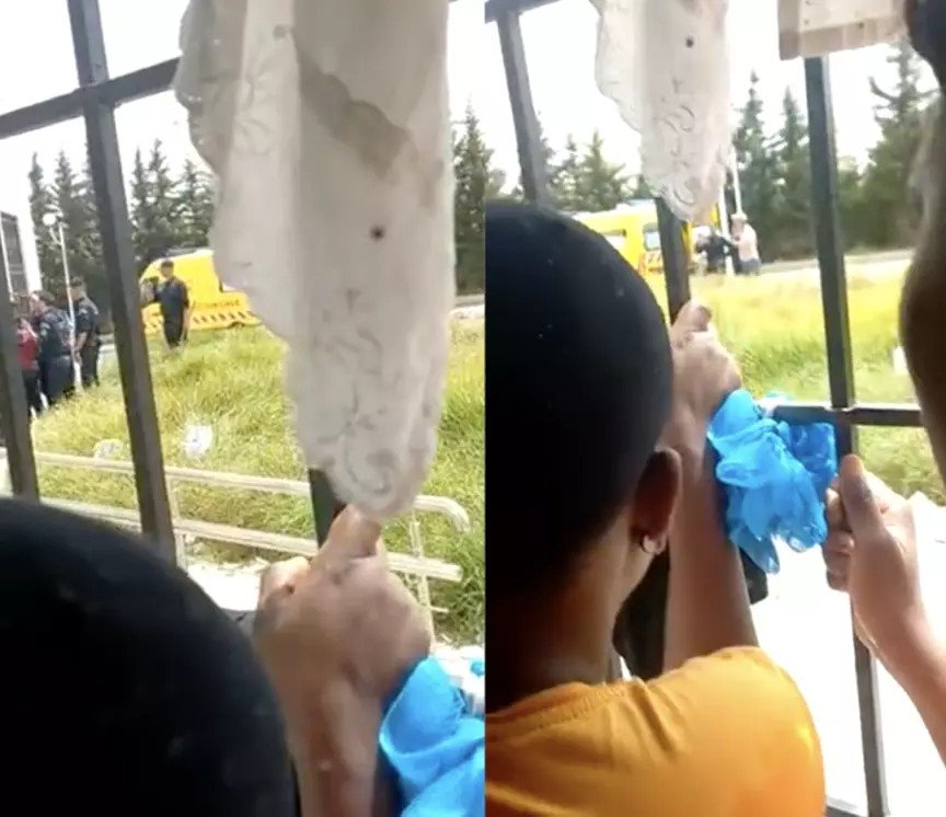 Captures d’écran de la seconde vidéo transmise à la rédaction des Observateurs. Plusieurs femmes tentent de voir ce qu'il advient de la mère et de l'enfant à travers la fenêtre du centre, où on distingue une ambulance. Crédit : DR