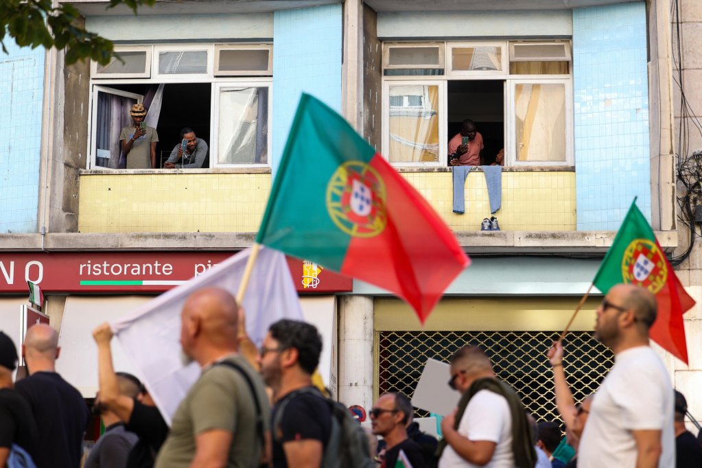 File photo: Migrants watching from windows as far-right Chega party supporters participate in a demonstration 'against uncontrolled immigration and insecurity in the streets in Portugal' in Lisbon | Photo: Jose Sena Goulao / EPA