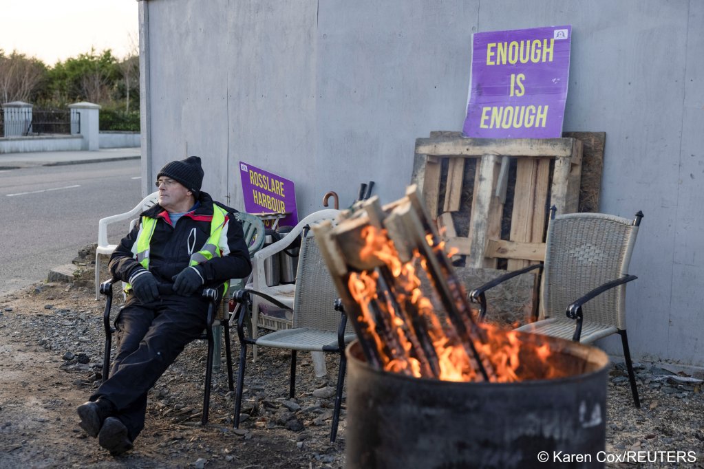 From file: Here a protester in Rosslare keeps up a vigil signalling 'enough is enough' regarding the government's migration policy and plans to house asylum seekers in a former hotel | Photo: Karen Cox / Reuters