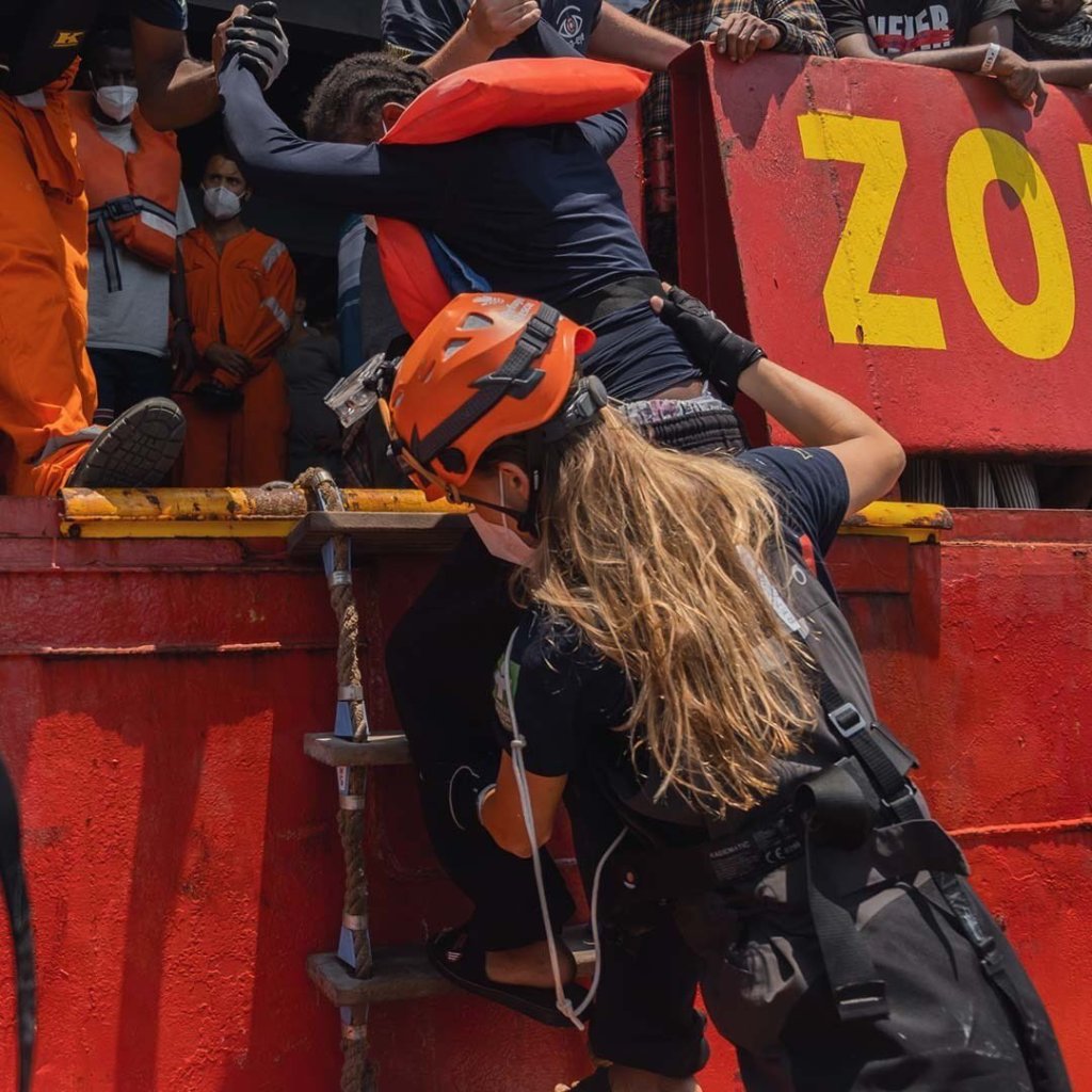 A crew member of Sea-Eye 4 helps one woman disembark | Source: @seaeyeorg and @MariaMaida7 Twitter feed