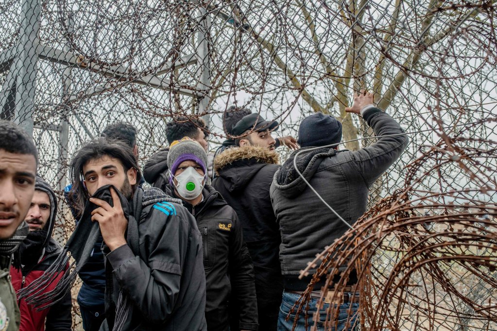Migrants in the buffer zone at the Turkey-Greece border try to remove fences near the Pazarkule crossing in Edirne, March 4, 2020 | Photo: B. Kilic/AFP