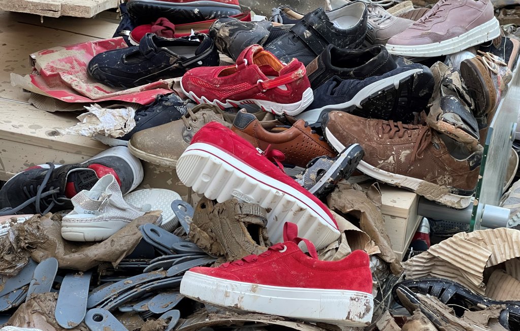 Shoes piled up on the street after the flood | Photo: Ekaterina Venkina