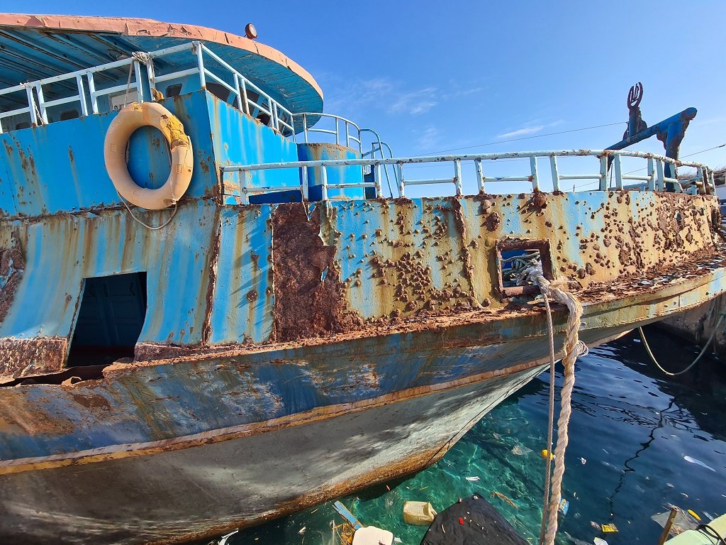 قارب استخدم في إيصال مهاجرين عبر المتوسط إلى سواحل لامبيدوزا، يرسو في ميناء الجزيرة ضمن منطقة خصصتها السلطات لتجميع تلك القوارب، 16 تشرين الأول\أكتوبر 2021. شريف بيبي