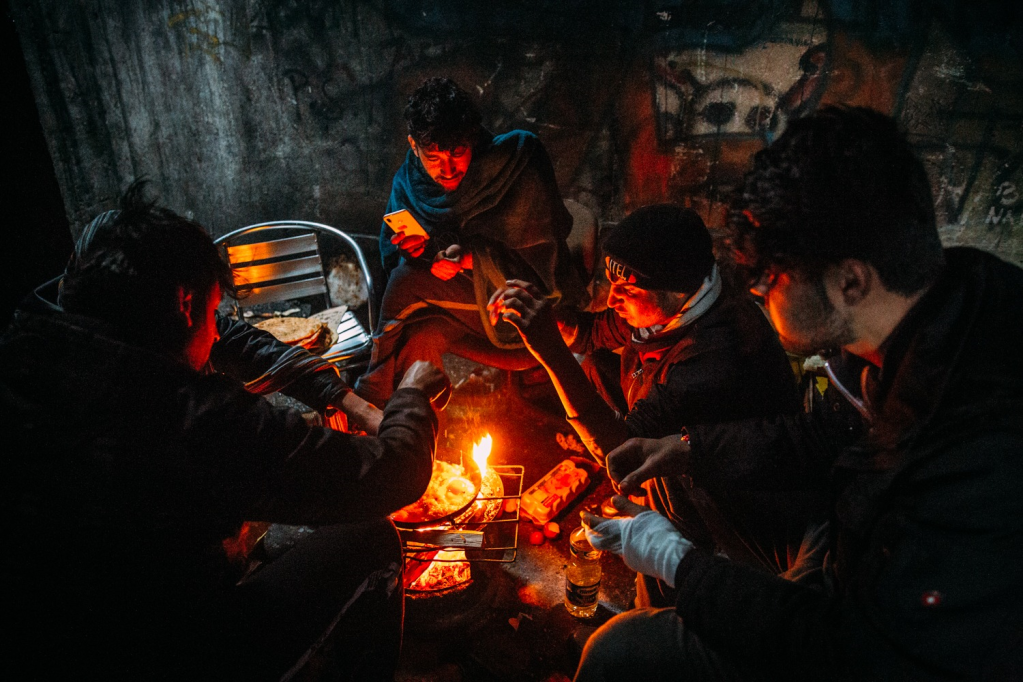 Migrants huddling around a fire inside an abandoned building in Bihać, Bosnia in January 2021 | Photo: Alea Horst
