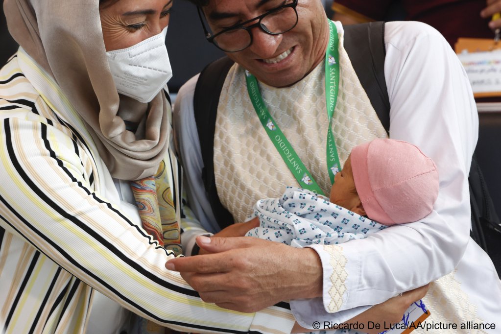 Afghani refugees holding a baby during a welcome ceremony after landing from Islamabad, Pakistan, at Rome's Fiumicino international airport, Italy, on July 27, 2022 | Photo: Riccardo De Luca/Anadolu Agency/Picture-alliance