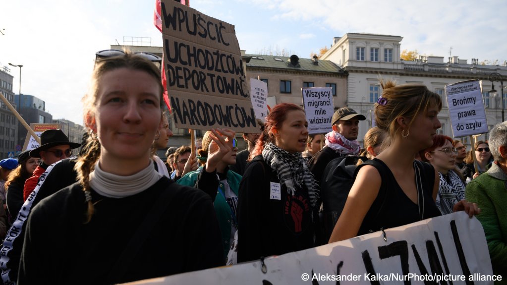 People hold signs that read ''Let in migrants, deport nationalists'' and shout slogans as they rally against the Polish Prime Minister Donald Tusk's decision to suspend the right to asylum within Poland's territory in Warsaw, Poland, on October 27, 2024 | Photo: picture-alliance