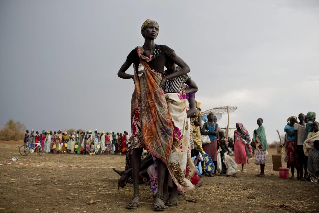 Women and children displaced by fighting between rebel soldiers and government troops wait in line to collect their food rations in Mingkaman, South Sudan | Photo: EPA/Kaste Holt/UNICEF