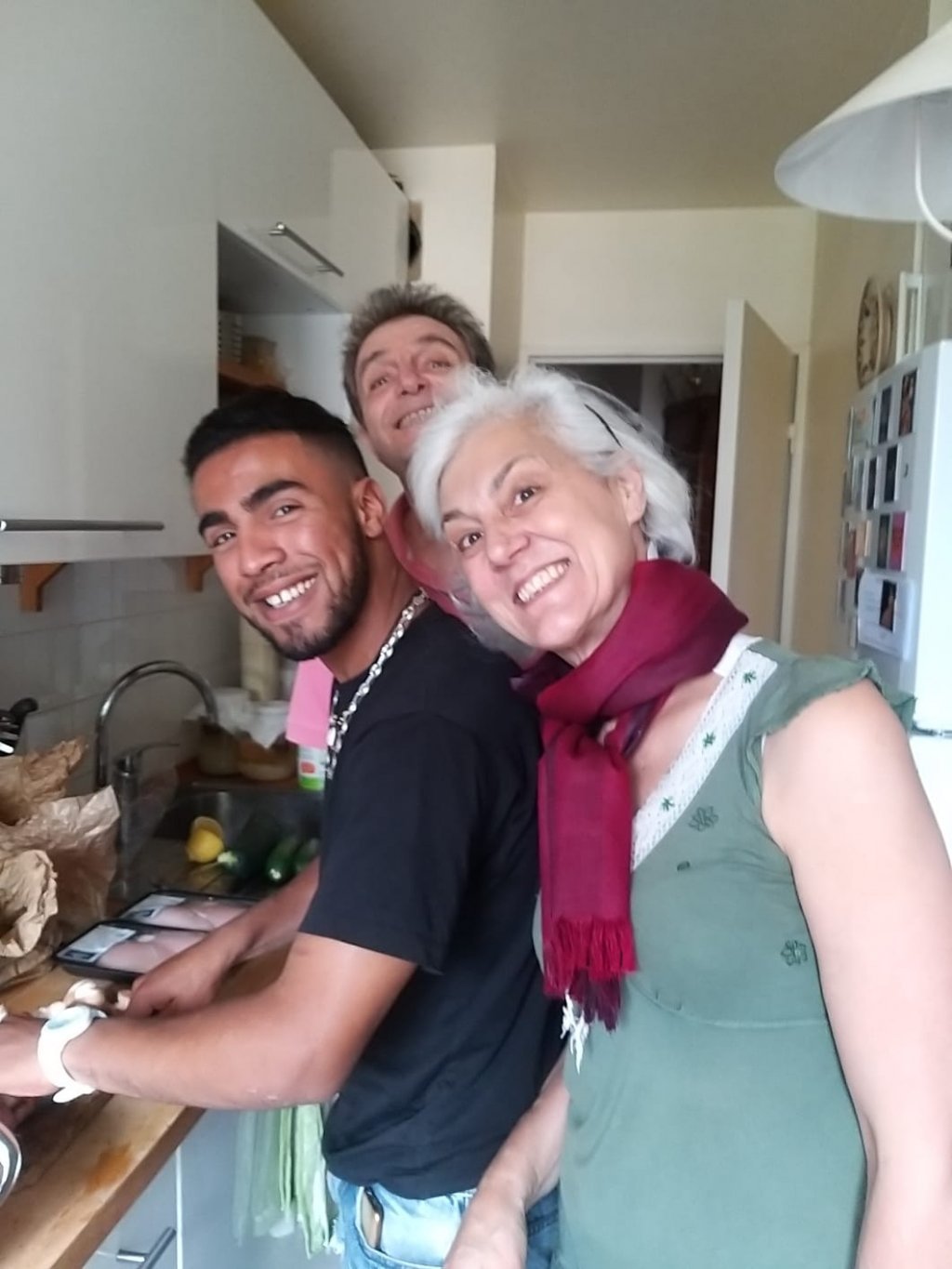 Ayoub prépare un tajine avec Sergio et Giovanna dans leur appartement à Paris | Photo : Dany Mitzman / InfoMigrants
