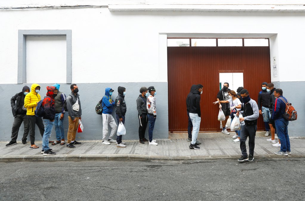 Les migrants à la rue font la queue devant les locaux d'une ONG pour récupérer un peu de nourriture. Crédit : Reuters