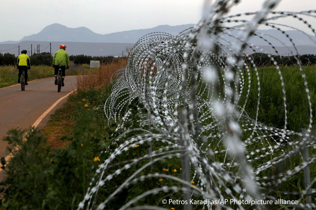 Razor wire is seen along the southern side of a U.N buffer zone that cuts across the ethnically divided Cyprus, during sunset near village of Astromeritis, Tuesday, March 9, 2021 | Photo: Picture alliance/ASSOCIATED PRESS/Petros Karadjias
