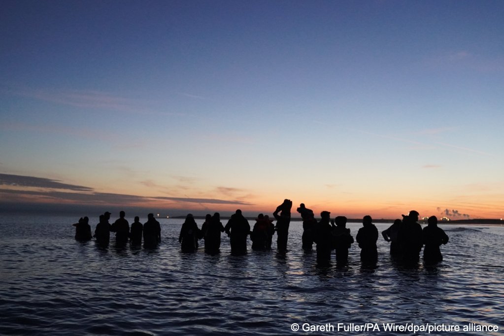 The new British-French scheme that began this week doesn't seem to have yet had an effect on the numbers of migrants attempting to cross the Channel. This group were waiting at dawn in the sea near Gravelines, France to board a small boat towards the UK | Photo: Gareth Fuller/PA Wire/dpa/picture alliance