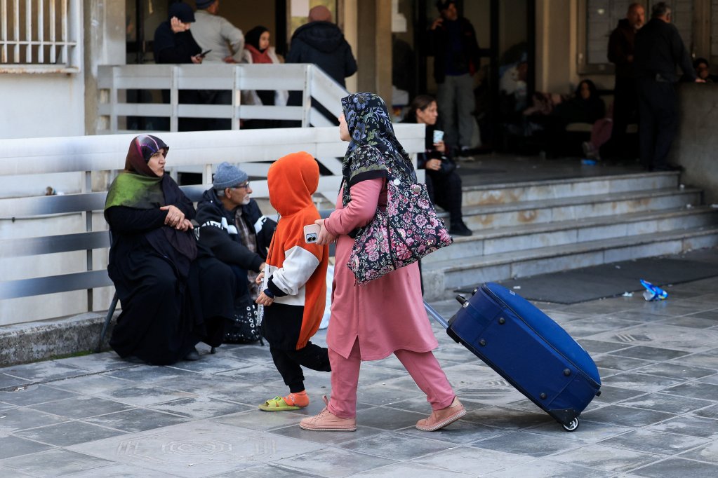 A displaced woman with a child walk outside a school-turned-shelter, following an escalation between Hezbollah and Israel amid the U.S.-Israeli conflict with Iran, in Beirut, Lebanon, March 3, 2026. REUTERS/Mohamed Azakir