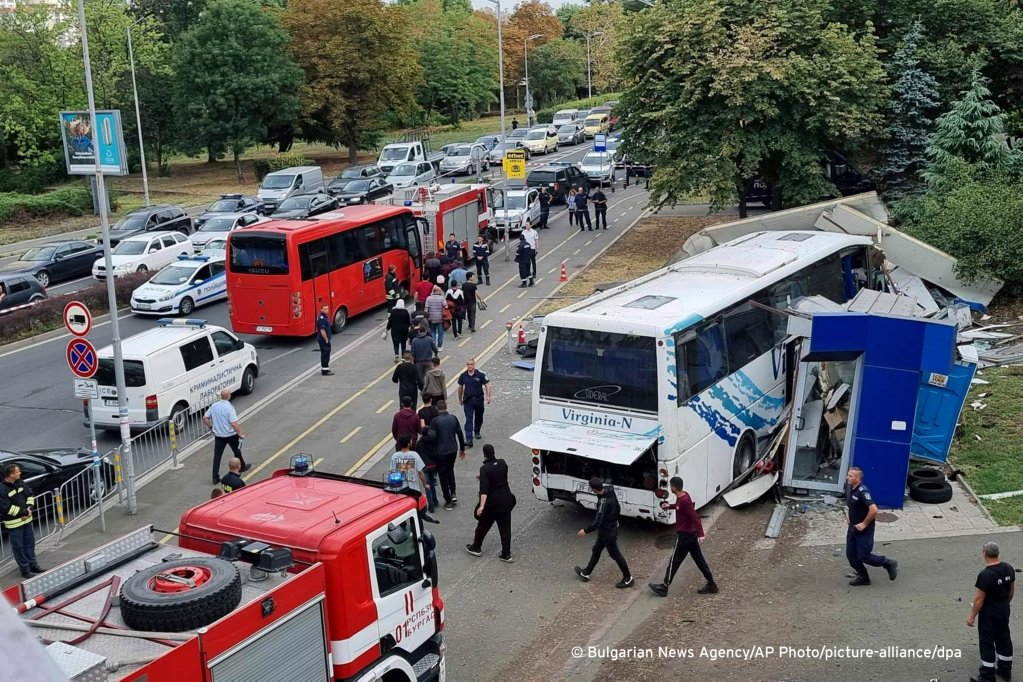 Police escort migrants to board a bus at the scene of an incident in Burgas on August 25, 2022. Two police officers were killed as they tried to stop a bus carrying migrants | Photo: Bulgarian News Agency via AP