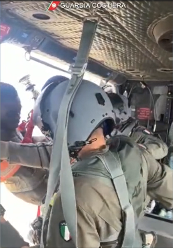 The moment two of the 32 migrants were brought aboard the Italian coast guard helicoopter | Photo: Screenshot from video provided by the Italian coast guard