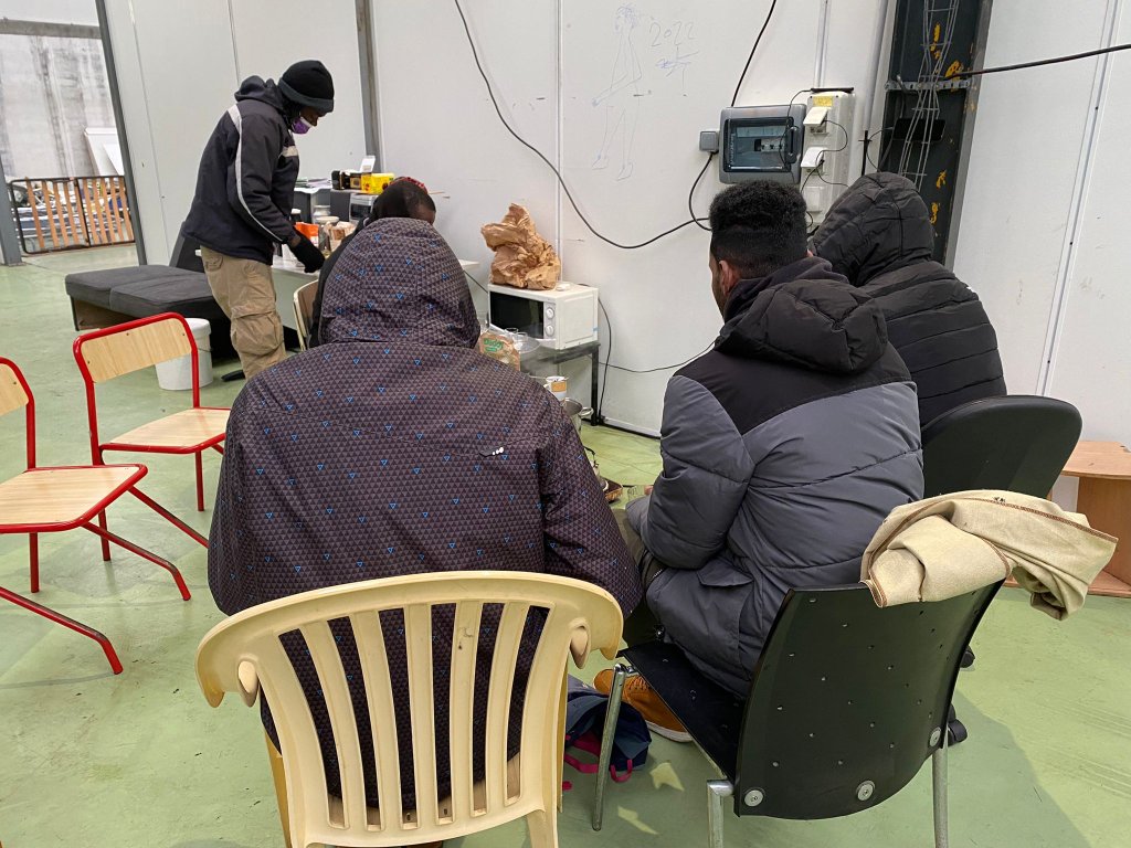 Des migrants se réchauffent autour d'un café. Crédit : InfoMigrants