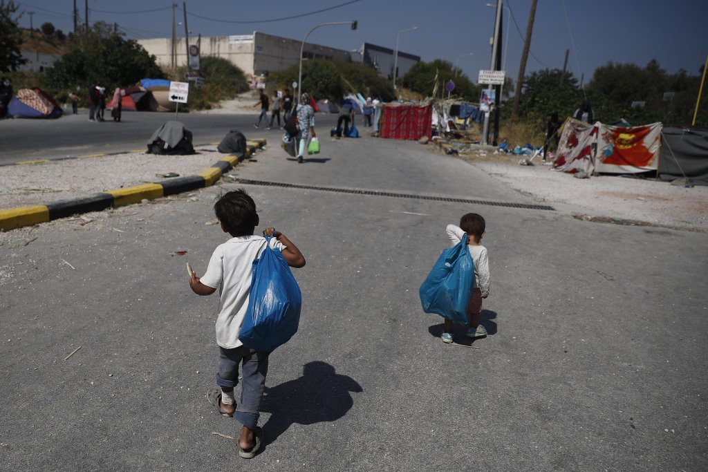 Two boys walk on a road where asylum seekers from the destroyed Moria camp find shelter near a new temporary camp, Mytilene, Greece, September 14, 2020 | Photo: EPA/DIMITRIS TOSIDIS