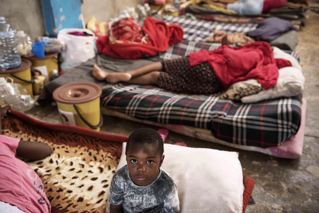 A child sits on a mattress laid on the floor of the women's section of the Al-Nasr detention center in Zawiya, Libya | Photo: ANSA/UNICEF