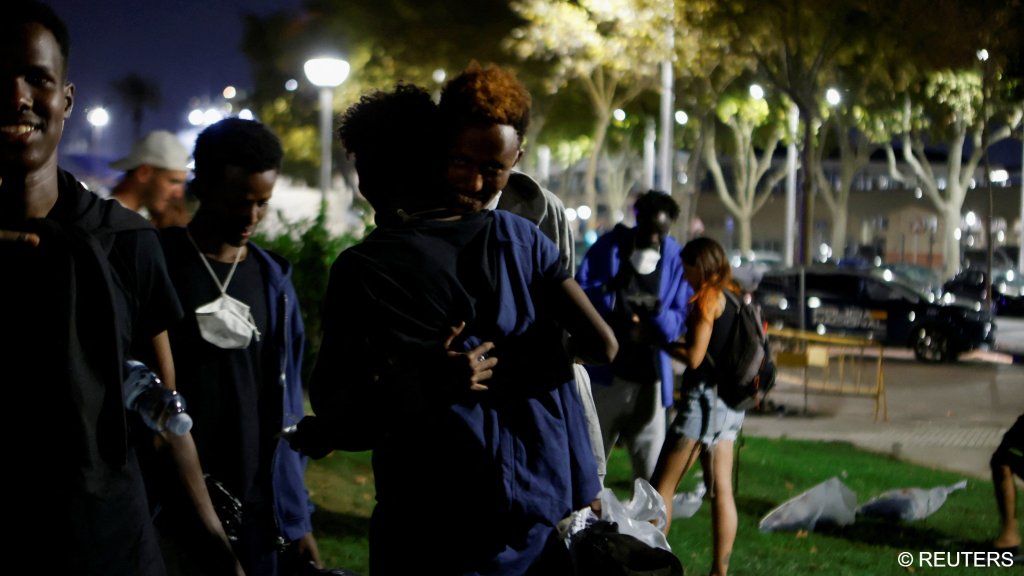 Two sub-saharan migrants embrace in a public park after arriving from Algeria earlier in the day, as more than 30 boats carrying about 600 irregular migrants have reached the Balearic Islands since Monday, according to officials, in Palma de Mallorca, Spain, on August 12, 2025 | Photo: REUTERS/Francisco Ubilla