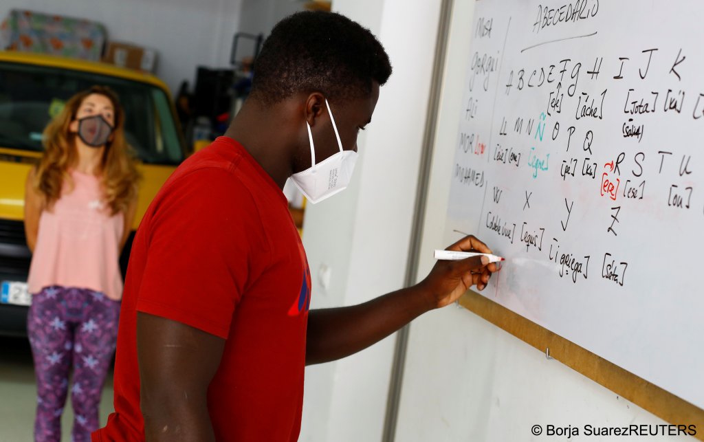 Ali Thiam, a migrant from Senegal, is taught Spanish by volunteer teacher Isabel Florido in Tito Martin's private garage, in Las Palmas on the island of Gran Canaria, Spain July 21, 2021 | Photo: REUTERS/Borja Suarez