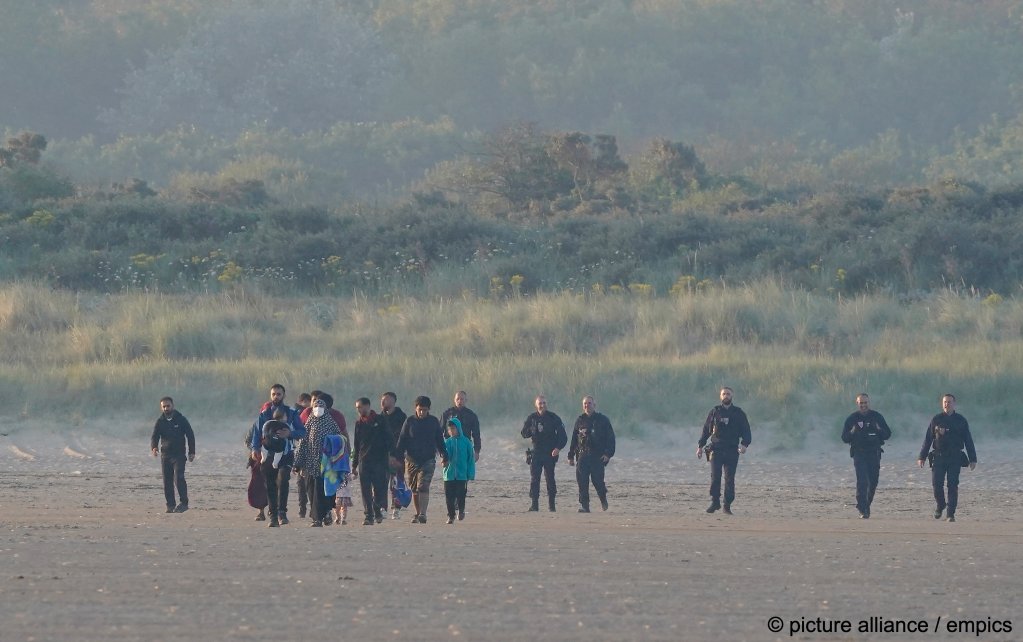 Police on the beach at Gravelines approach a group of migrants to try and prevent them from attempting a risky crossing from France | Photo: Gareth Fuller / picture alliance / empics