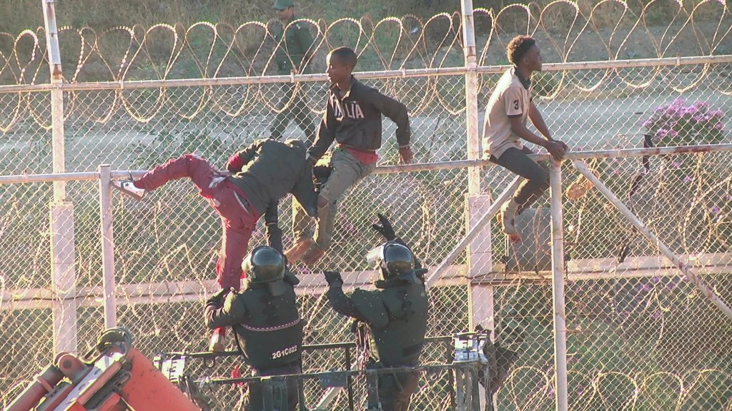 Migrants attempting to climb the barbed wire fence between Morocco and the Spanish enclave of Ceuta | Photo: Reuters