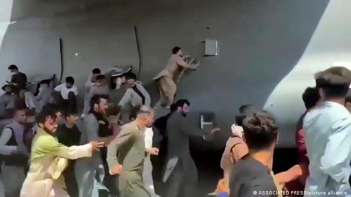 تلاش افغانهای درمانده به بالا شدن به هواپیمای نظامی امریکا که در حال شروع پرواز است (۱۶ آگست ۲۰۲۱)