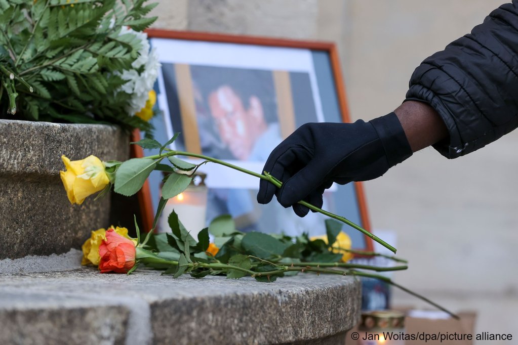 A woman lays a rose on the steps of the police station in memory of Oury Jalloh on January 7, 2022 | Photo: Jan Woitas/dpa/picture-alliance